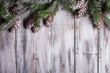 White shabby Christmas border with snow covered pinecones