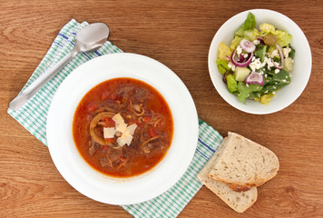 lamb in tomato sauce with cheese and green salad