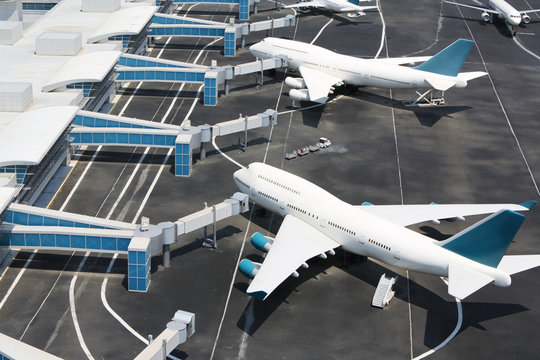 Models of modern white aircraft standing at miniature airport.
