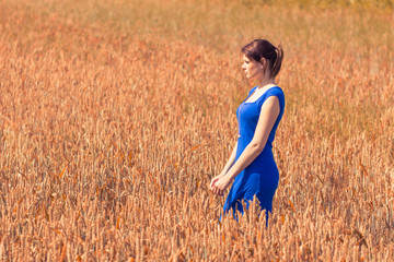 Beautiful young woman with blue dress in nature