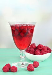 Jelly with fresh berries on green wooden table