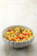 Piatto di pasta fredda con mozzarella, pomodori e basilico