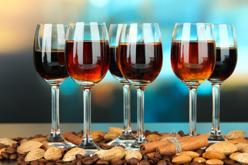 Glasses of liquors with almonds and coffee grains,