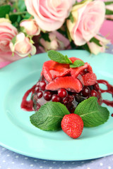 Tasty jelly dessert with fresh berries, on pink roses