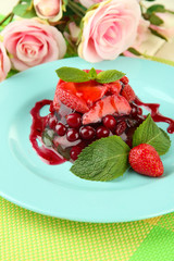 Tasty jelly dessert with fresh berries, on pink roses