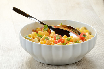 Piatto di pasta fredda con mozzarella, pomodori e basilico