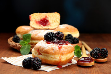 Tasty donuts with berries on wooden table