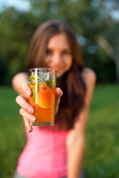Girl's hand holding glass with orange juice