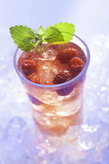 cold refreshment with raspberries, mint and soda on ice cubes.