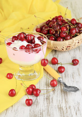 Delicious cherry dessert in glass vase on wooden table close-up