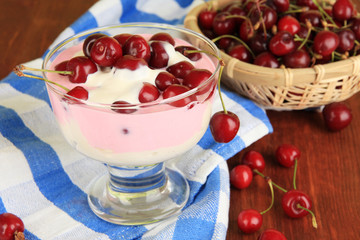 Delicious cherry dessert in glass vase on wooden table close-up