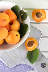 Naklejka na ściany i meble Apricots in plate on board on napkin on wooden table