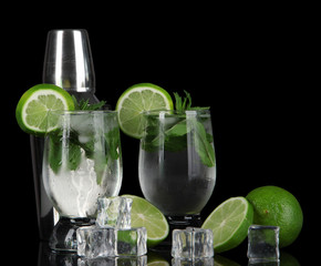 Glasses of cocktail with ice on black background