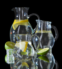 Glass pitchers of water isolated on black