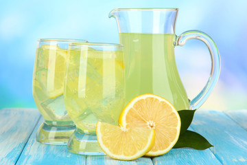 Delicious lemonade on table on blue background