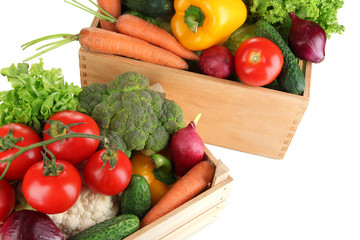 Fresh vegetables in wooden boxes on white background