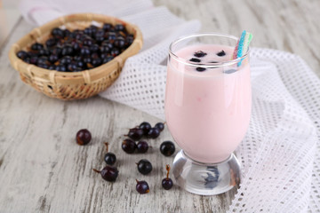 Delicious milk shake with blackberry on wooden table close-up