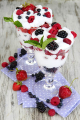 Natural yogurt with fresh berries on wooden background