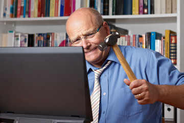 Senior schlägt voller Wut auf seinen Laptop