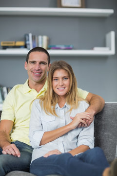 Smiling couple sitting on their couch