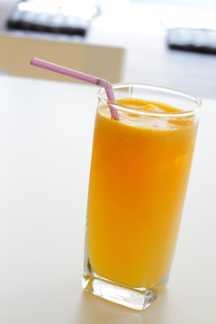A glass of orange juice in a cafe setting