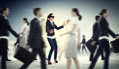 Businesswoman in blindfold among group of people