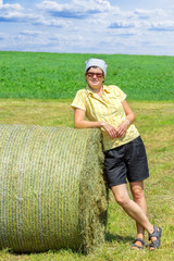 Naklejka na ściany i meble Farmer standing next to hay