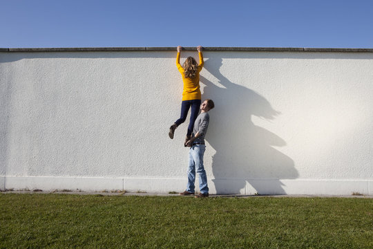 Germany, Bavaria, Munich, Young couple climbing wall