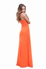 Beauty in orange dress. Full length of attractive young woman in