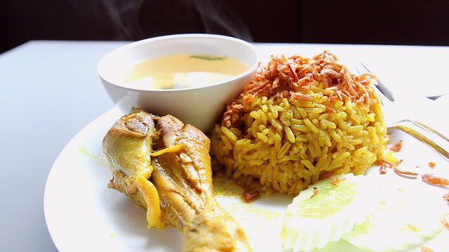 chicken curry with pilau rice on white plate