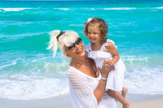 Grandmother and granddaughter are having fun on the beach