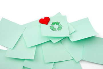 Recycle sign on green sheet of paper with heart