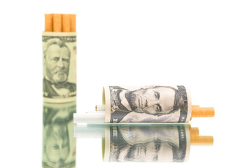 expensive habit. money and cigarettes on white background