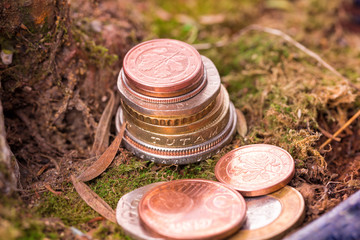 Different old coins stacked on the ground