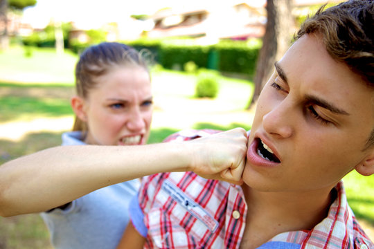 Angry girlfriend punching boyfriend