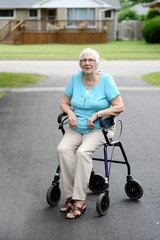Fototapeta na wymiar Tired senior woman sitting on walker