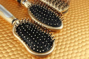 Hairbrushes on color background