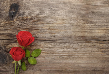 Red roses on wooden table. Blank board, copy space