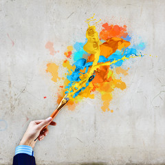 Human hand holding paint brush