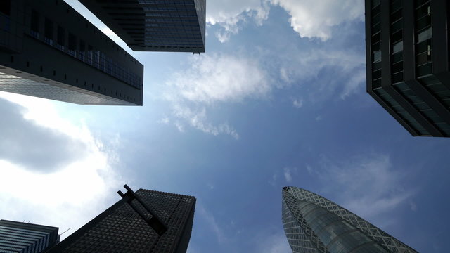東京　高層ビル街 空を見上げる。ダイナミックに流れる雲 イメージ
