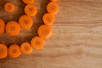 Chopped carrot circles  against wood