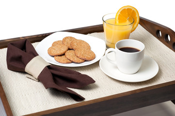 Orange juice, cookies and cup of coffee over wooden tray