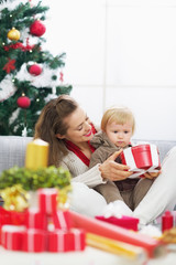 Obraz na płótnie Canvas Happy mother showing baby christmas present box