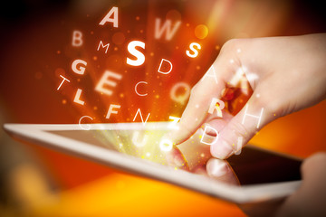 Finger pointing on tablet pc, letters concept