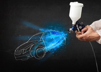 Worker with airbrush gun painting hand drawn car lines
