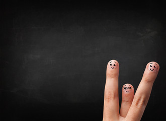 Happy smiley fingers looking at empty black chalboard