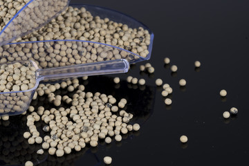 Clear shovel with white pepper scattered from it