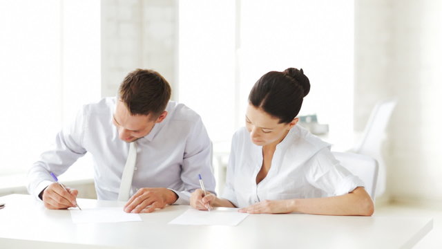 man and woman signing a contract