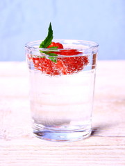 Water in glass with raspberries and mint