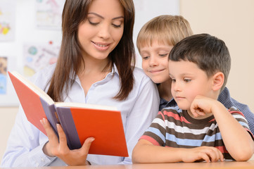 Obraz premium Teacher reading a book. Confident young teacher reading a book t